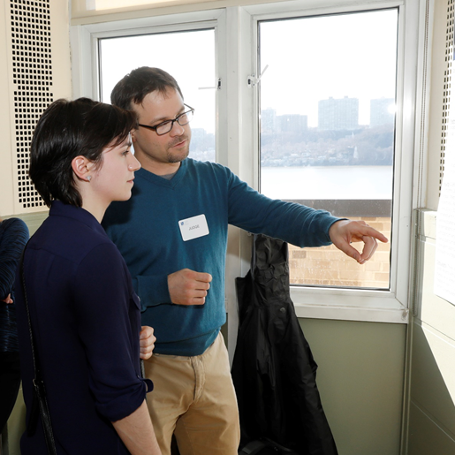 Two scientists looking at a poster, with one pointing and providing comments.